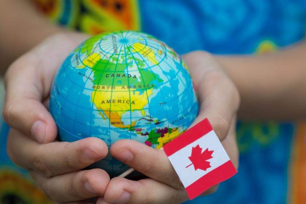 Globe in hand with the Canada flag